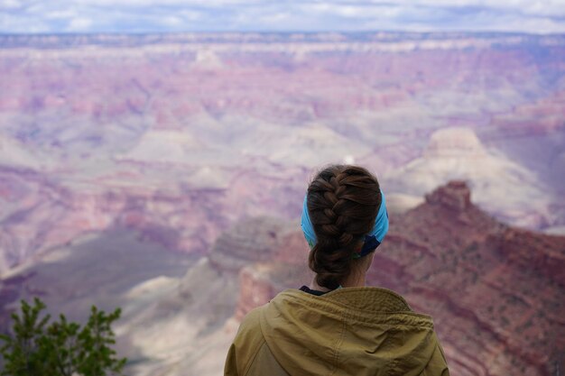 Foto vista posteriore di una donna che guarda una catena montuosa