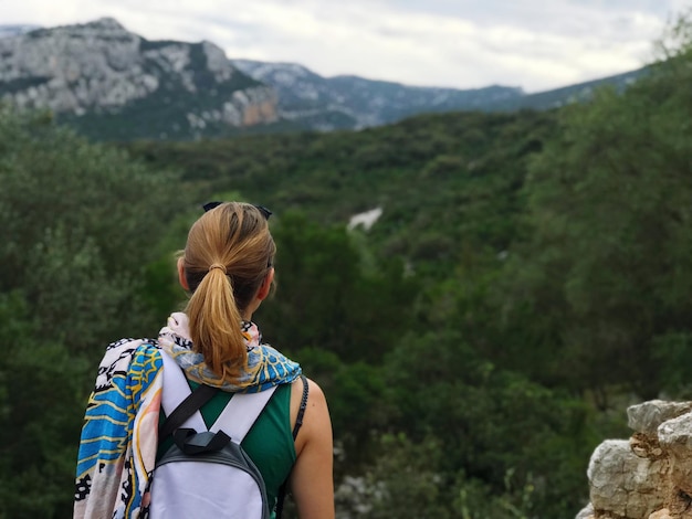 Foto vista posteriore di una donna che guarda la montagna