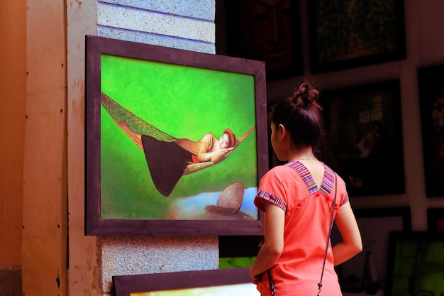 Photo rear view of woman looking at painting