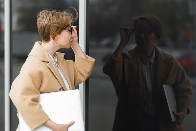 Rear view of woman looking at the reflection in glass wall