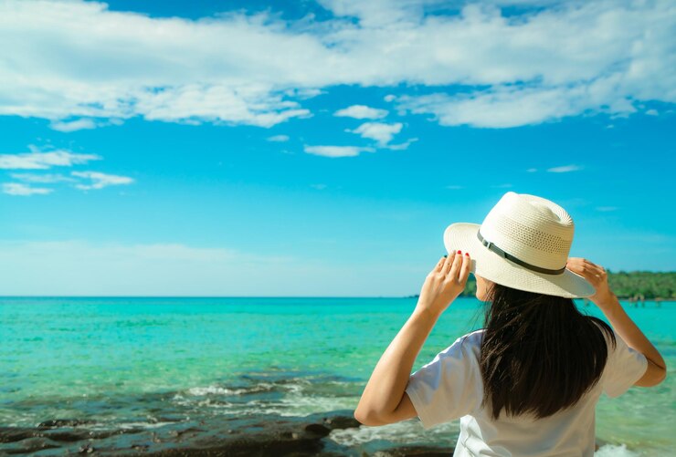 Photo 空を背景に海を見ている女性の後ろの景色