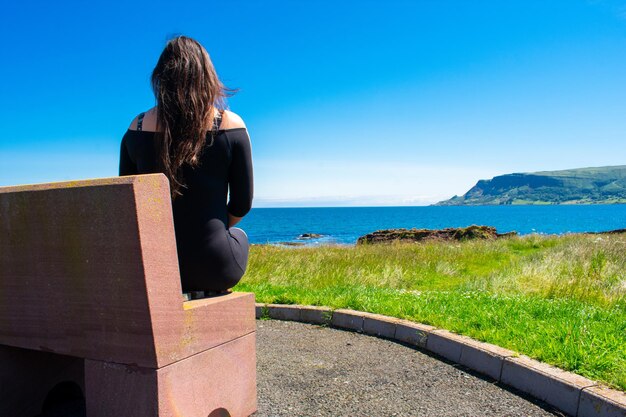 Rear view of woman looking at sea against sky