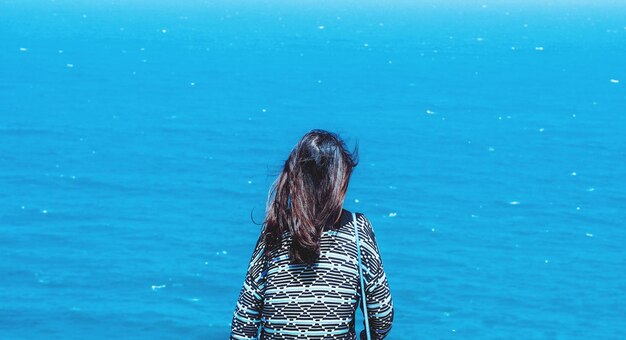 Foto vista posteriore di una donna che guarda il mare