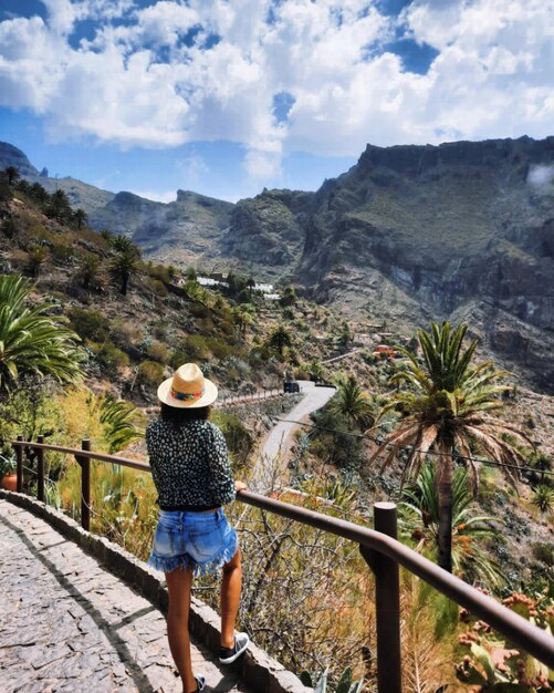 Foto vista posteriore di una donna che guarda la valle verde vulcanica