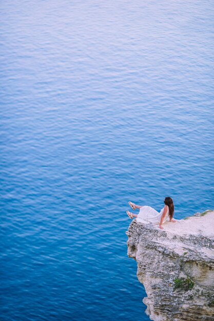 Foto vista posteriore di una donna che si affaccia sul calmo mare blu