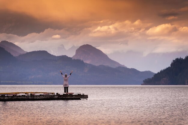 Foto vista posteriore di una donna che si affaccia su un lago calmo