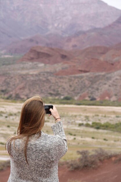 Photo rear view of woman photographing against sky