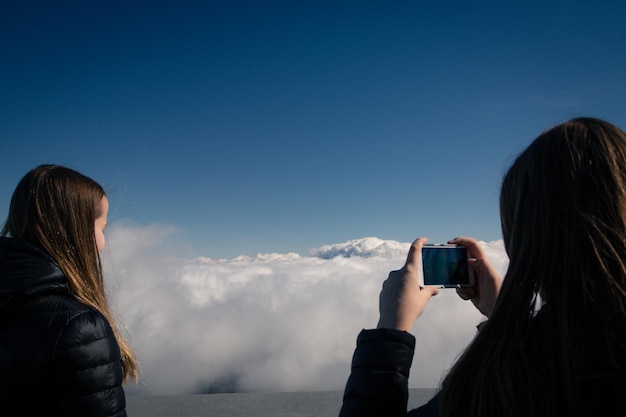 Photo rear view of woman photographing cloudy sky