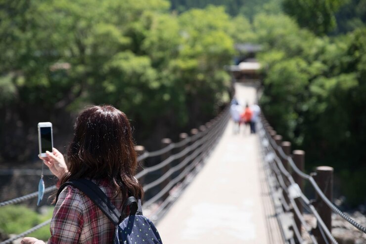 Photo 歩道橋で写真を撮っている女性の後ろの景色