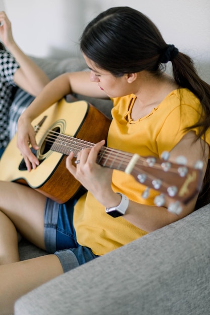 Rear view of woman playing guitar