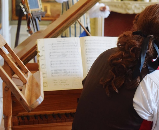 Photo rear view of woman playing piano