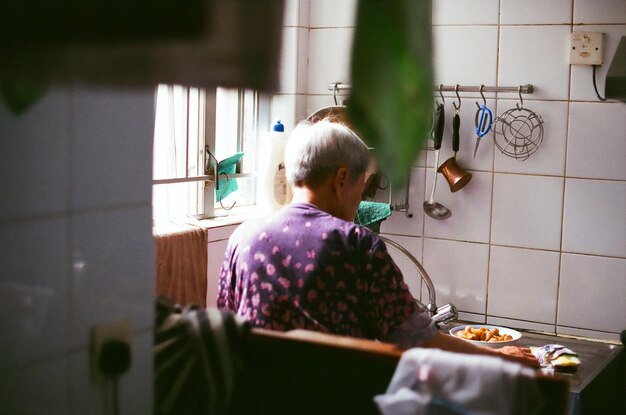 Photo rear view of woman preparing food in kitchen at home