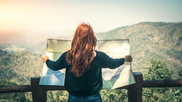 Photo rear view of woman reading map against sky