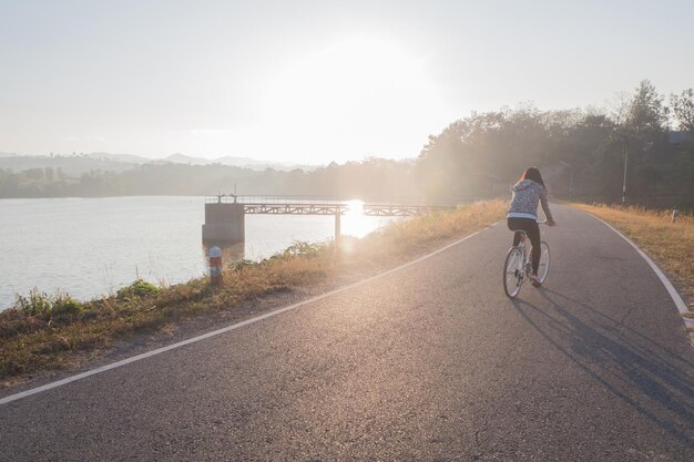 Rear view of woman riding bicycle on road