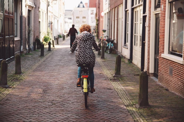 rear view of woman riding bicycle on road
