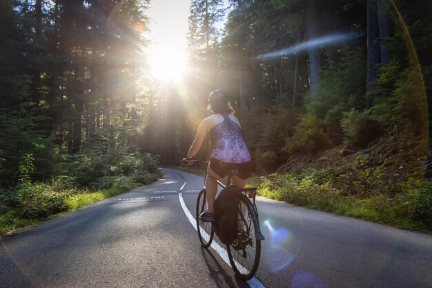 Photo rear view of woman riding bicycle on road