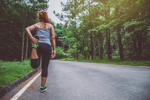 rear view of woman on road amidst trees