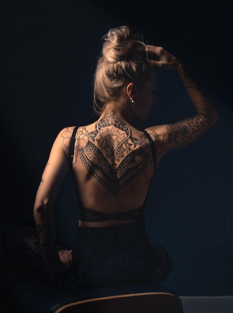 rear view of woman sitting against black background
