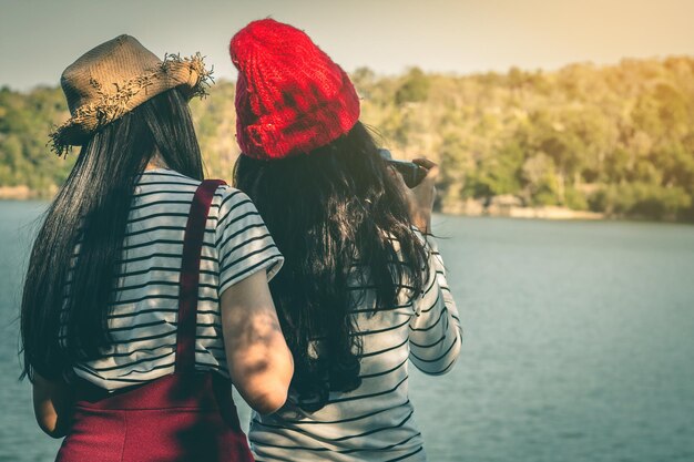 Foto vista posteriore di una donna seduta contro il fiume