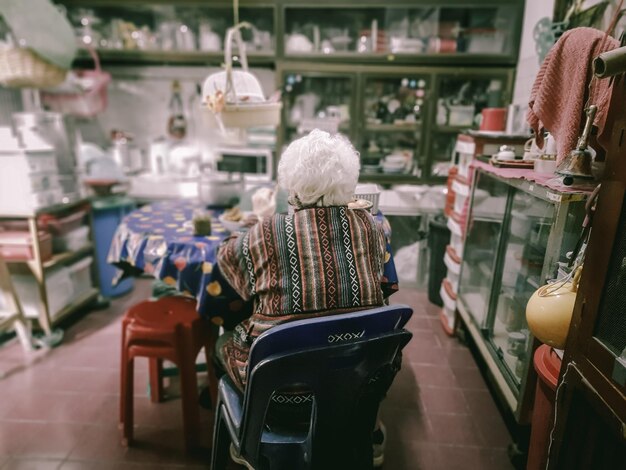 Foto vista posteriore di una donna seduta su una sedia