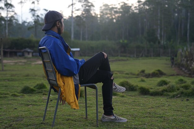 Rear view of woman sitting on field