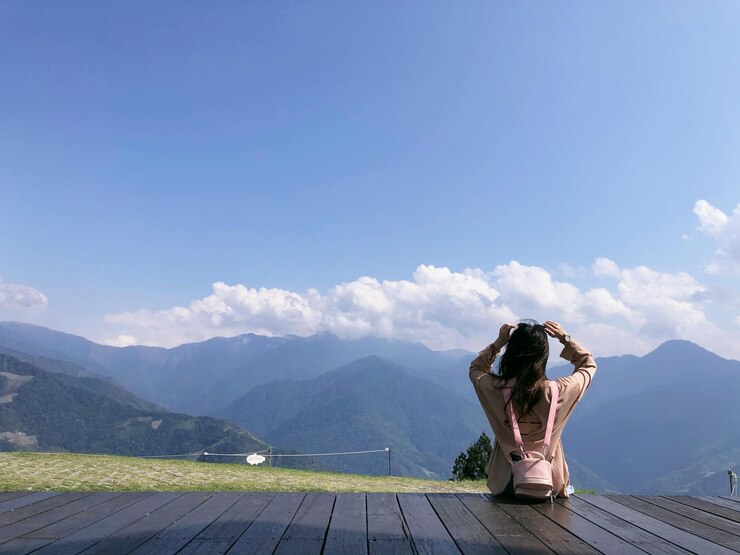 Photo 山の向こうの歩道橋に座っている女性の後ろの景色