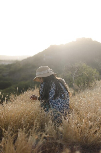 Photo rear view of woman sitting on grass against sky