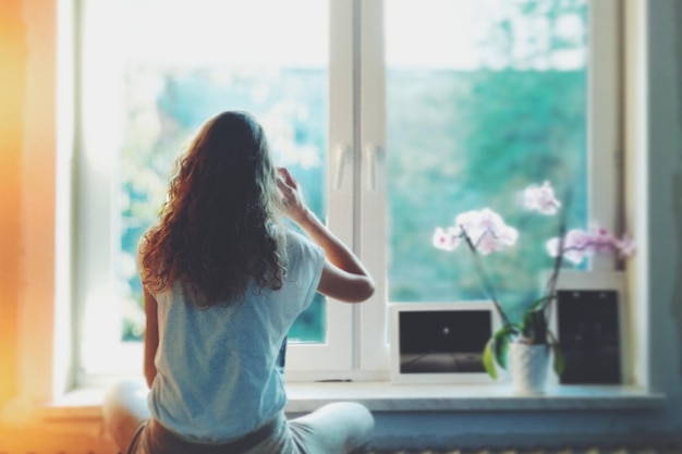 Rear view of woman sitting at home