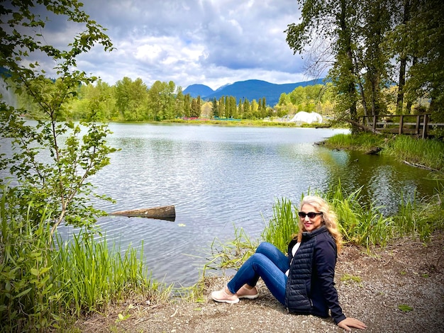 Rear view of woman sitting on lake