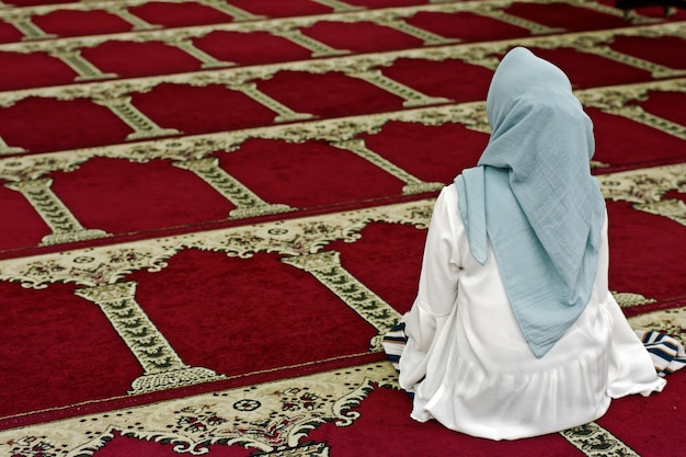 Photo rear view of woman sitting in mosque