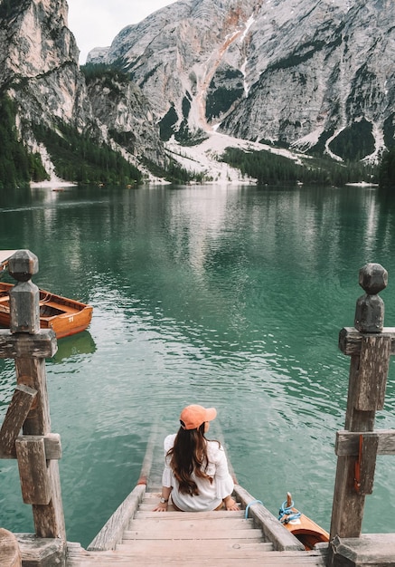 Photo rear view of woman sitting on pier at lake