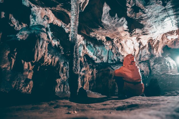 Foto vista posteriore di una donna seduta su una roccia