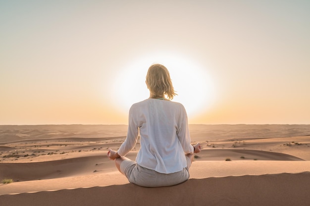 Photo rear view of woman sitting on sand at beach