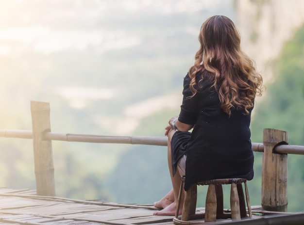 Foto vista posteriore di una donna seduta su uno sgabello