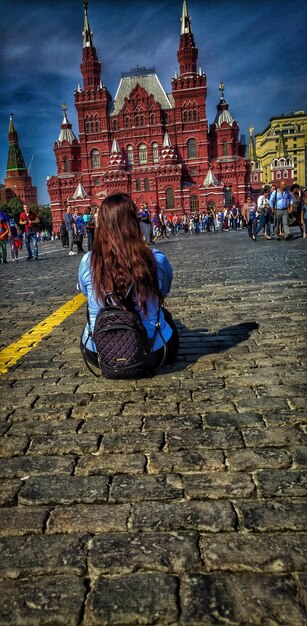 Photo rear view of woman sitting on street in city