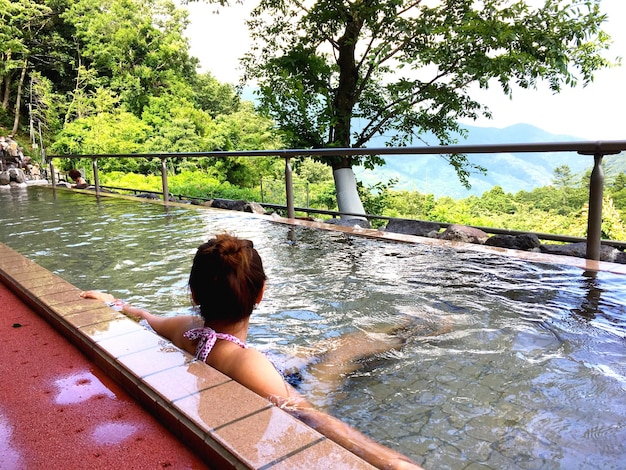 Rear view of woman sitting in swimming pool