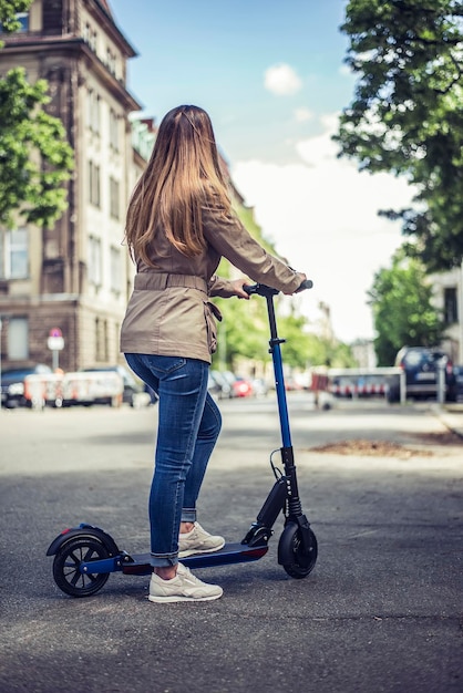 道路でスケートボードをしている女性の後ろの景色