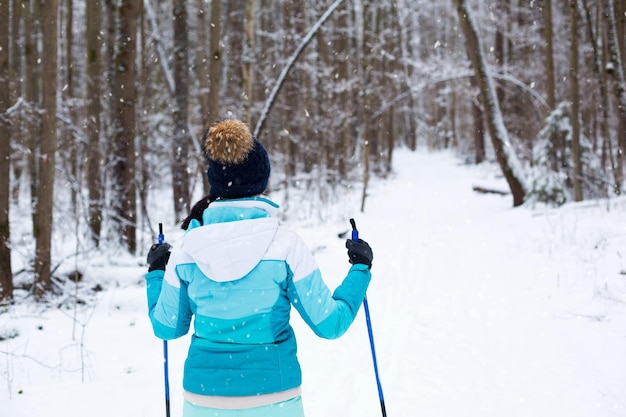 Foto vista posteriore di una donna che scia su un campo coperto di neve