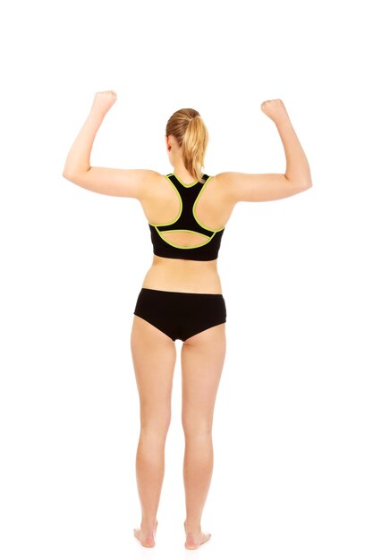 Rear view of woman in sports clothing while standing against white background