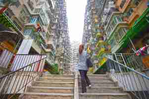 Photo rear view of woman on staircase amidst buildings in city