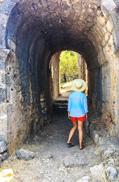 Foto vista posteriore di una donna in piedi contro l'arco