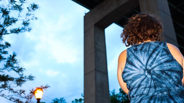 Rear view of woman standing against blue sky