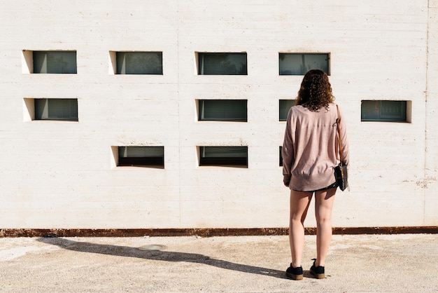 Foto vista posteriore di una donna in piedi contro un edificio