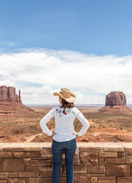 Rear view of woman standing against cloudy sky