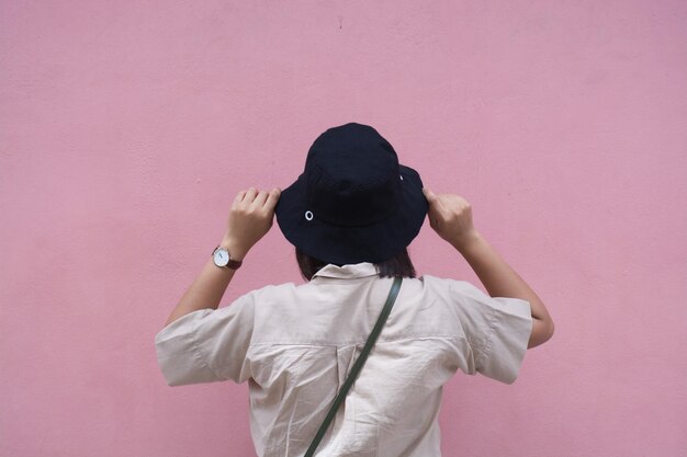 Photo rear view of woman standing against pink wall