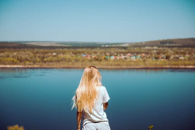 Photo rear view of woman standing against river