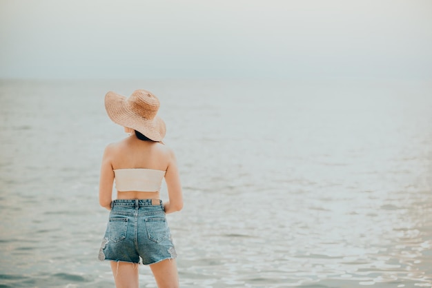 海に背を向けて立っている女性の後ろの景色