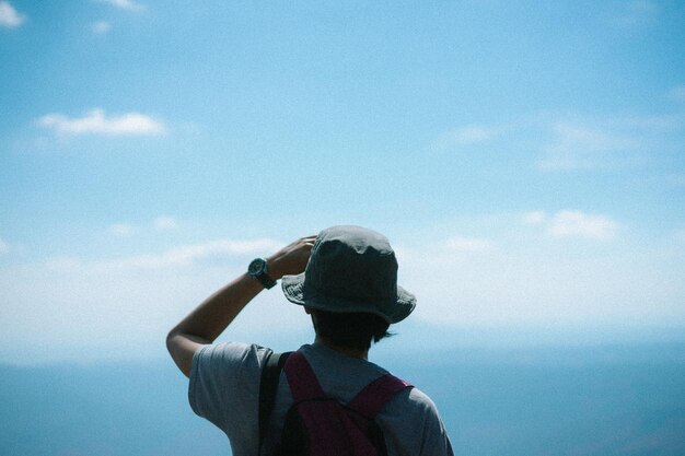 空に向かって立っている女性の後ろの景色