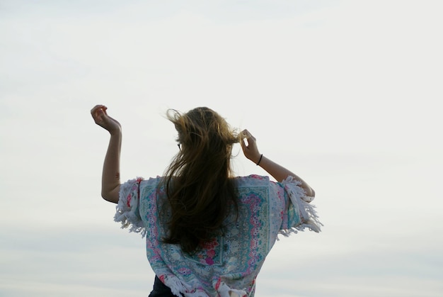 Rear view of woman standing against sky