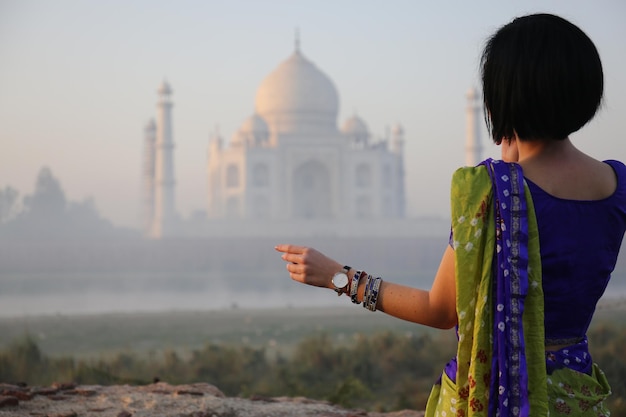 Photo rear view of woman standing against temple